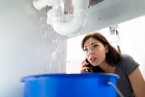 Woman making a phone call for a plumbing emergency