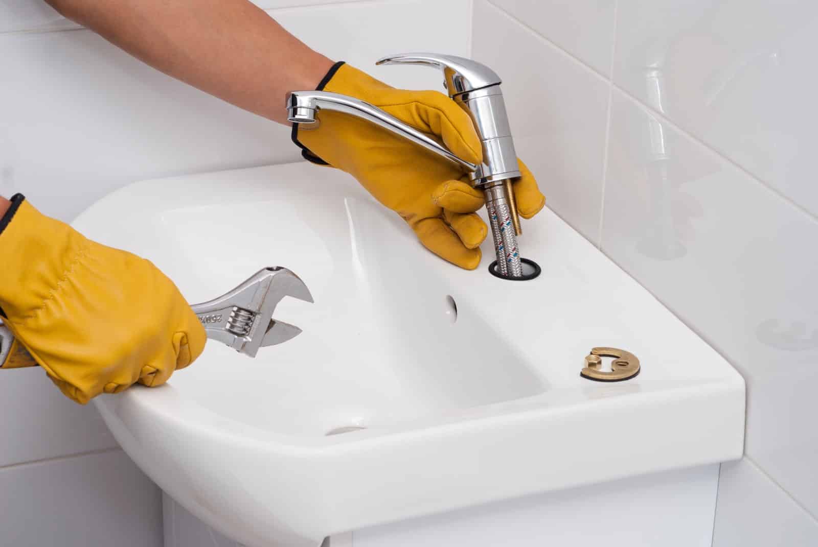 Plumber installing a new kitchen sink faucet